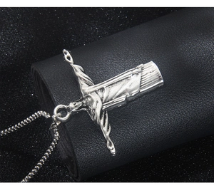 Détail macro du collier pendentif Christ Rédempteur en acier vintage sur cuir noir élégant