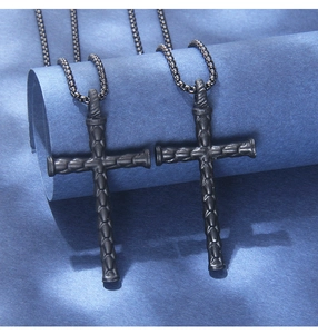 Macro shot of two black stainless steel cross necklaces with unique scale-like textures