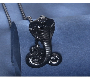 Detail of gun black cobra pendant with fine scale textures and rounded bead chain necklace