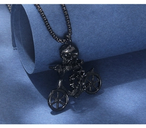 Macro shot of punk style black skull biker pendant with rugged chain on blue texture