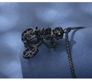 Detail of gothic black skull riding bicycle pendant on black box chain necklace