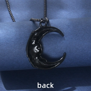 Matte black crescent moon rose necklace back view on dark textured background