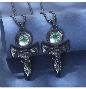 Close-up of black compass necklaces with Eye of Horus and mystical wing details