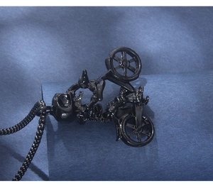 Macro shot of a punk style black skull riding a motorcycle pendant on a steel chain