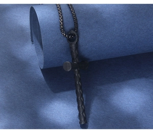 Detail shot of matte black nail-style cross pendant with textured steel chain
