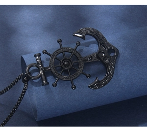 Close-up of black stainless steel nautical anchor and ship wheel pendant on a thick chain