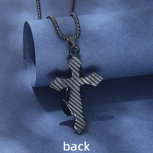 Retro black stainless steel prayer cross necklace with textured back on blue paper