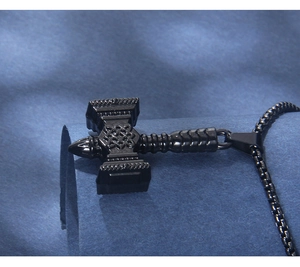 Detailed macro view of black matte Mjolnir pendant with intricate Celtic knot patterns