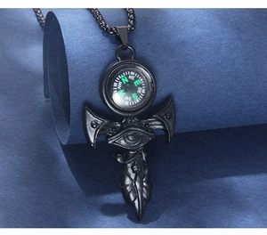Detail showing Eye of Horus compass necklace with black metal chain on textured background
