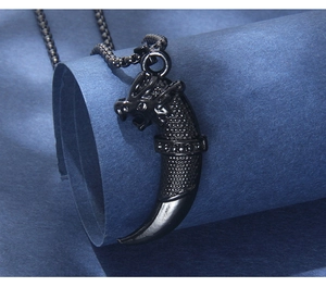 Macro shot of punk black dragon head pendant with wolf tooth texture and link chain