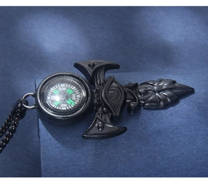 Detailed macro view of a black gothic compass pendant with arrow and cross elements