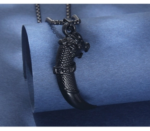Detailed macro view of black stainless steel wolf tooth pendant with dragon scale textures
