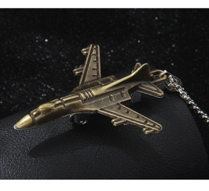 Détail du pendentif avion de chasse en bronze vintage avec chaîne argentée de style rétro
