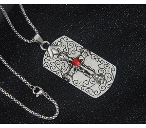Détail du pendentif carré croix avec zircon rouge sur un collier à chaîne maille miroir