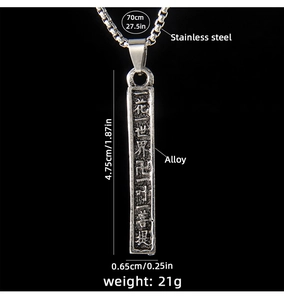 Gros plan d'un pendentif colonne en acier vintage avec écriture bouddhiste gravée