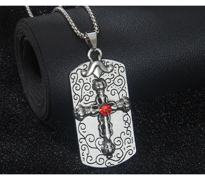 Détail du pendentif croix crâne avec strass rouge sur chaîne argentée vintage