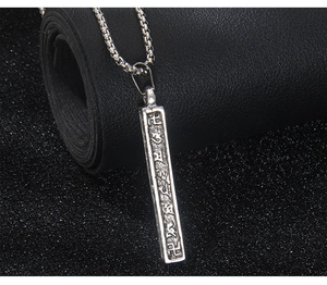 Vue détaillée du pendentif colonne vintage en acier inoxydable avec symboles de mantra