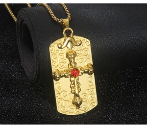 Vue détaillée du pendentif carré doré avec croix en pierre rouge et motifs en filigrane