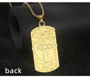Gros plan du dos d'un collier pendentif carré doré avec un relief de croix complexe