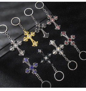 Macro shot of gothic cross keychains featuring colorful rhinestones and vintage floral carvings