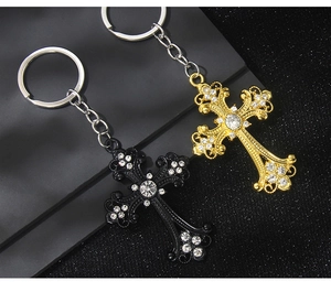 Baroque hollow cross keychain with sparkling crystals in gold and matte black finish