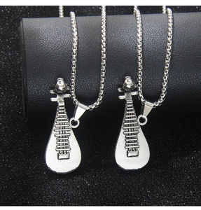 Gros plan de deux pendentifs pipa en argent vintage avec des gravures métalliques fines