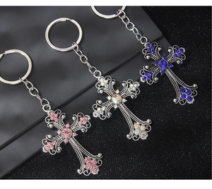 Detailed view of vintage cross keychains with pink, white, and blue sparkling rhinestones