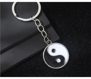 Macro shot of Yin Yang Tai Chi pendant keychain with silver metal and glossy finish