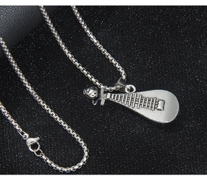 Macro d'un pendentif Pipa en argent rétro avec chaîne maille box sur fond noir