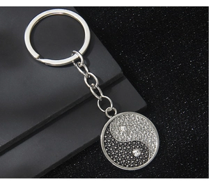 Close-up of Yin Yang metal keychain featuring black and silver sparkling rhinestones