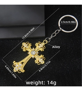 Detailed macro view of a gold-tone cross keychain with sparkling white rhinestones and measurements
