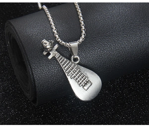 Détail d'un pendentif pipa en acier inoxydable avec motif d'ours sur cuir noir