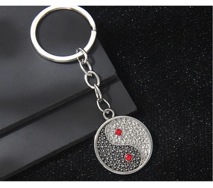 Macro view of Yin Yang keychain with black and white rhinestones and red gem eyes