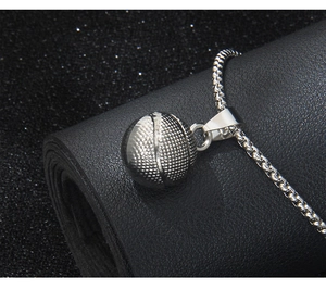 Close-up of silver 3D basketball pendant showing textured details on black background