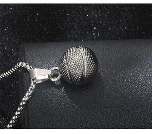 Detailed close-up of a silver 3D basketball pendant with fine texture and box chain