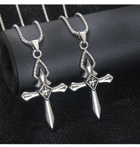 Gros plan de colliers croix en acier inoxydable gothique avec pendentifs en épée