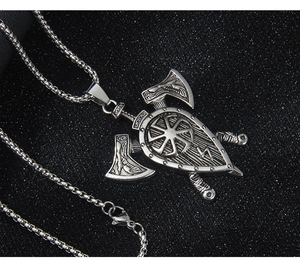 Gros plan du pendentif viking vintage en acier inoxydable avec doubles haches et bouclier