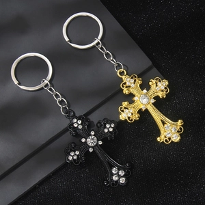 Vintage cross keychain with crystal rhinestones in gold and black finishes on dark base