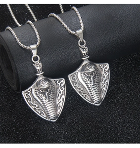 Detailed macro view of vintage stainless steel shield pendants with embossed cobra patterns