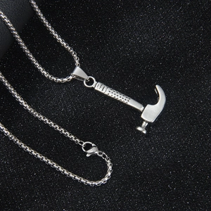 Collana con ciondolo a martello 3D in acciaio inossidabile su sfondo nero testurizzato