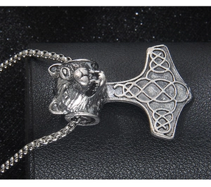 Détail du collier viking avec tête de loup, marteau de Thor et motifs celtiques