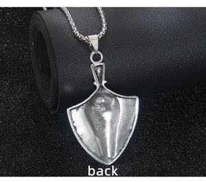 Macro view of the back of a vintage silver shovel pendant with a textured finish