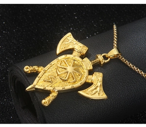 Détail macro du pendentif bouclier Viking doré avec haches doubles et runes slaves