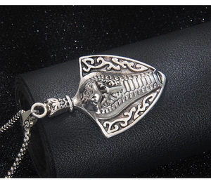 Detailed close-up of a silver-toned cobra snake pendant with an oxidized vintage finish
