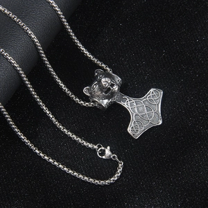 Collier marteau de Thor viking avec pendentif tête de loup sur fond noir texturé