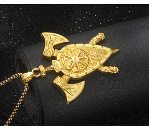 Gros plan du pendentif bouclier et hache double Viking doré avec gravure slave Kolovrat