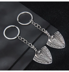 Detailed close-up of retro silver cobra shield keychain with intricate metal carving