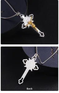 Détails recto et verso du pendentif croix en acier bicolore sur chaîne à billes