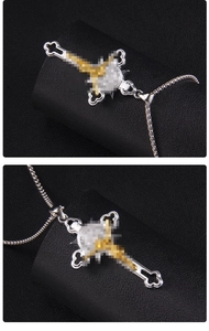 Détails macro d'un pendentif croix gothique bicolore or et argent avec chaîne box
