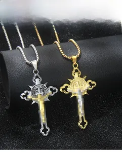 Dettaglio dei ciondoli a croce vintage in oro e argento con rilievi su pelle nera